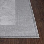 Tapis gris moderne sur parquet brun.