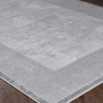 Tapis gris moderne sur sol en bois.