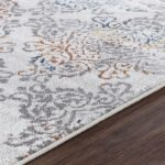 Tapis floral sur plancher en bois.