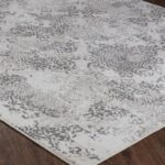 Tapis à motifs gris et blanc sur parquet.