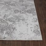 Tapis élégant gris et blanc sur plancher bois.