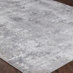 Tapis texturé gris sur plancher en bois.