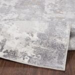 Tapis moderne gris et blanc sur sol en bois.
