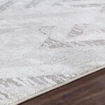 Tapis gris moderne sur plancher en bois.