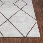 Tapis moderne motifs géométriques sur plancher en bois.