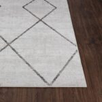 Tapis design géométrique sur parquet brun.