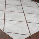 Tapis moderne à motif géométrique sur plancher en bois.