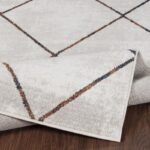 Tapis moderne géométrique sur plancher en bois.