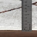 Règle métallique mesurant tapis blanc.