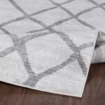 Tapis motif géométrique gris et blanc.