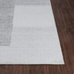 Tapis moderne gris sur sol en bois brun.