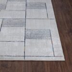 Tapis moderne géométrique sur plancher en bois.