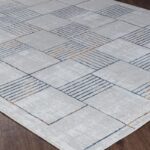 Tapis moderne géométrique gris sur plancher en bois.