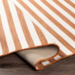 Tapis rayé orange et blanc sur sol en bois