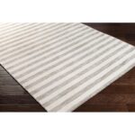 Tapis à rayures beige sur plancher de bois.