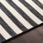 Tapis rayé noir et blanc sur sol en bois