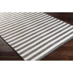 Tapis à rayures noires et blanches sur parquet.
