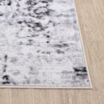 Tapis moderne noir et blanc sur parquet.