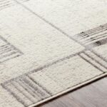 Tapis beige moderne avec motifs géométriques.
