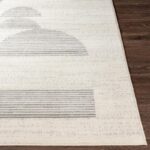 Tapis moderne beige à rayures sur plancher en bois.