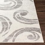 Tapis à motifs géométriques gris et blancs.