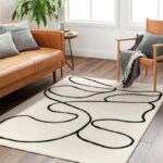 Salon moderne avec canapé en cuir et tapis décoratif.