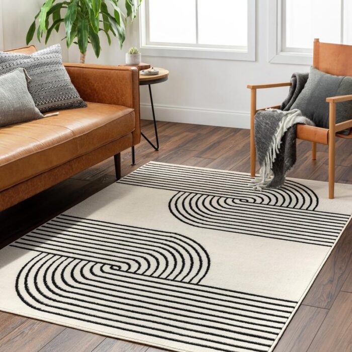 Salon moderne avec canapé cuir et tapis graphique.