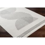 Tapis moderne gris et blanc, design géométrique.