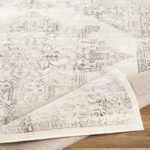 Tapis vintage crème sur plancher en bois.