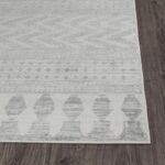 Tapis moderne gris avec motifs géométriques sur plancher bois.