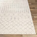 Tapis beige à motifs géométriques sur parquet.