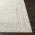Tapis motif géométrique blanc et gris.