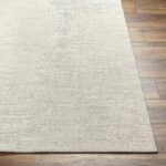 Tapis beige texturé sur plancher en bois