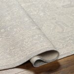 Tapis beige texturé enroulé sur plancher en bois