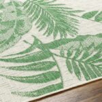 Tapis à motif tropical vert et blanc.