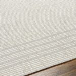 Tapis texturé beige sur plancher en bois.