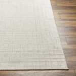 Tapis beige sur sol en bois.