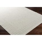 Tapis beige texturé sur parquet brun