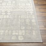 Tapis moderne gris sur plancher de bois.