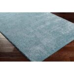 Tapis moelleux bleu sur plancher en bois
