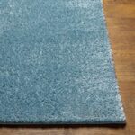 Tapis bleu sur plancher en bois.