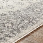 Tapis moelleux beige avec motifs sur plancher en bois.