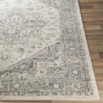 Tapis vintage gris sur plancher en bois.