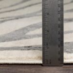 Règle métallique sur tapis.