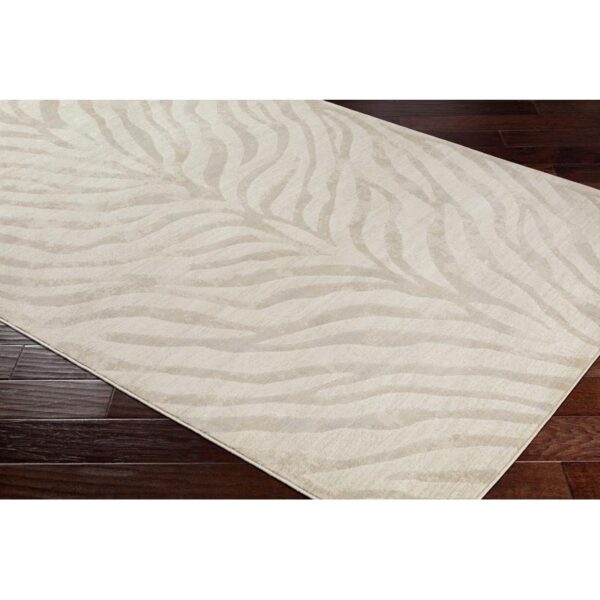 Tapis motifs zébrés beige sur plancher bois.