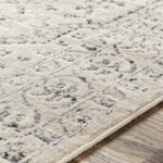 Tapis beige à motifs sur plancher en bois.
