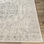 Tapis beige à motifs orientaux sur sol en bois.