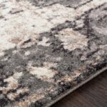 Tapis à motifs géométriques en gris et beige.