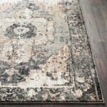 Tapis vintage beige et noir sur parquet.