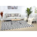 Salon moderne avec canapé et tapis à motifs.